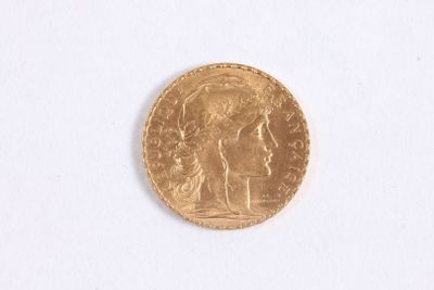 gros plan d'une pièce d'or sur une surface blanche