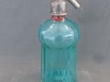 une bouteille en verre bleue munie d'un robinet en métal