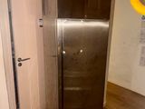 an image of a kitchen with a refrigerator in the middle of the floor