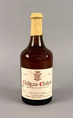 une image représentant une bouteille de vin de Château-Chalon posée sur une surface grise