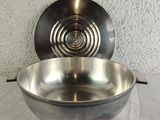 a metal bowl that is sitting on a table