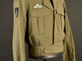 an army uniform on a mannequin stand against a black background