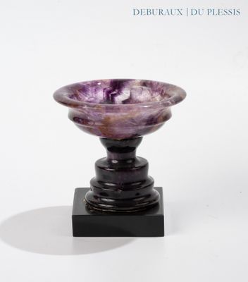 a purple marble bowl sitting on a black stand