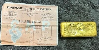 un gros plan d'un morceau d'or à côté d'un morceau de papier