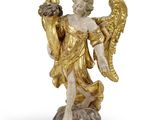 une image représentant une statue d'un ange tenant un oiseau sur un rocher
