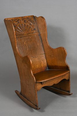 an old wooden rocking chair with a carved back and seat
