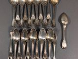beaucoup de cuillères en argent et de cuillères à soupe sur une table