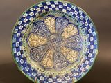 a blue and green plate with a decorative design on it