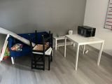 un canapé bleu dans une pièce où se trouvent une table et un micro-ondes