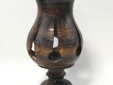 a brown vase that is sitting on a white surface