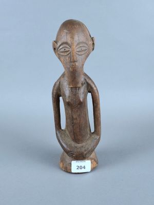 un gros plan sur une statue en bois représentant une personne, sur fond gris
