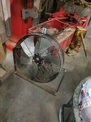 un ventilateur posé par terre dans une pièce