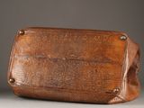 an image of a brown snake skin purse sitting on top of a table
