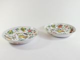 pair of chinese bowls with floral designs on them on a white surface
