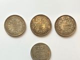 four different types of coins are shown on a white surface