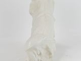 a figurine of a white cat sitting on a white surface