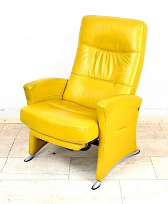 un fauteuil inclinable jaune posé sur un sol carrelé