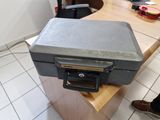 une petite boîte en métal posée sur une table en bois