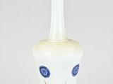 a white and blue vase sitting on top of a table