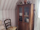 une chambre avec un lit, une chaise et une bibliothèque