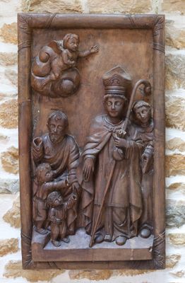des sculptures sur le mur d'un bâtiment représentant un homme et une femme avec un enfant