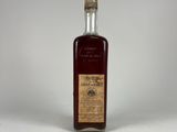 an empty bottle of liquor sitting on a white surface