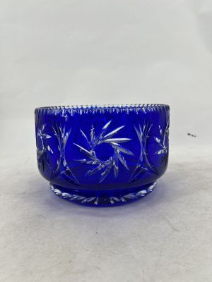 a close up of a blue glass bowl on a white surface