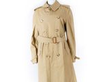 un mannequin vêtu d'un trench-coat beige et de collants noirs