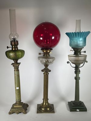 trois vases en verre de couleurs différentes sont alignés sur un fond blanc