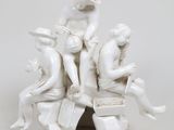 une statue représentant un groupe de personnes assises sur une pile de livres