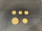 a close up of four gold coins on a black surface