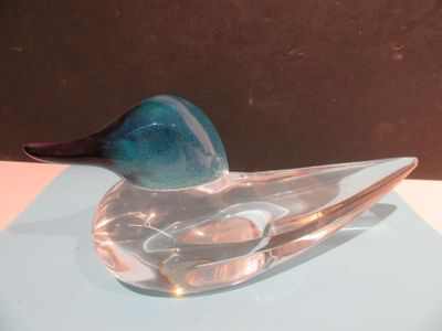a glass duck that is sitting on top of a table