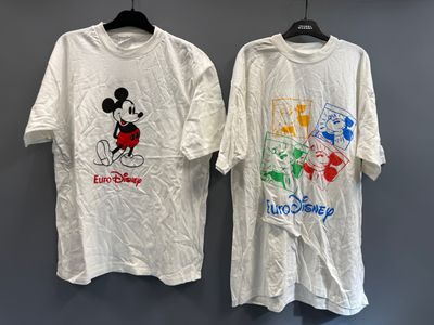 deux t-shirts à l'effigie de Mickey et Minnie accrochés à un mur