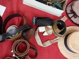 a lot of hats, belts, and other items laid out on a table
