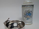 un bol en argent et un récipient en argent posés sur une table blanche