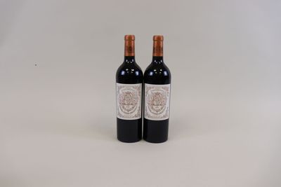 deux bouteilles de vin rouge posées l'une à côté de l'autre sur une surface blanche