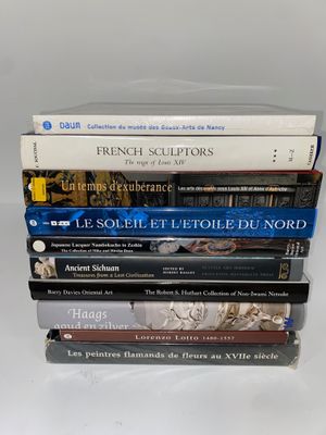 plusieurs livres empilés sur une surface blanche