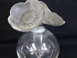 a glass vase with a flower on top of it