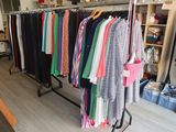 a lot of clothes hanging on a rack in a room