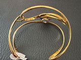 a close up of a gold bracelet on a black surface