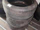 Plusieurs vieux pneus sont empilés sur une étagère dans un garage.