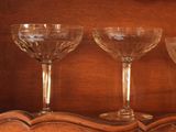 three wine glasses sitting on top of a wooden shelf