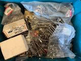 many screws in a blue bin with plastic bags
