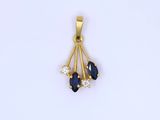 a close up of a gold pendant with blue and white stones