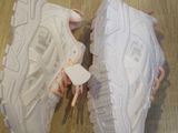 pair of white sneakers with pink laces on them sitting on a wooden floor