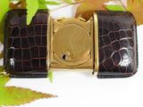 brown alligator skin belt with a gold buckle and a black alligator skin belt with a gold buckle and a brown alligator skin belt with a gold buckle