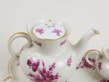 a tea pot and two cups sitting on a table