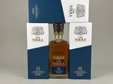 a bottle of nikka 12 year old whisky next to two boxes