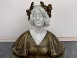 statue d'une femme coiffée d'une couronne, assise sur un socle en marbre