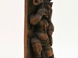 carved wooden sculpture of a man holding a pot on a stand